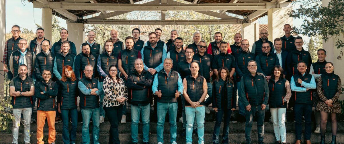 Groupe de personnes portant des gilets noirs et orange.
