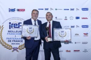 Deux hommes en costume tenant des trophées et des certificats.